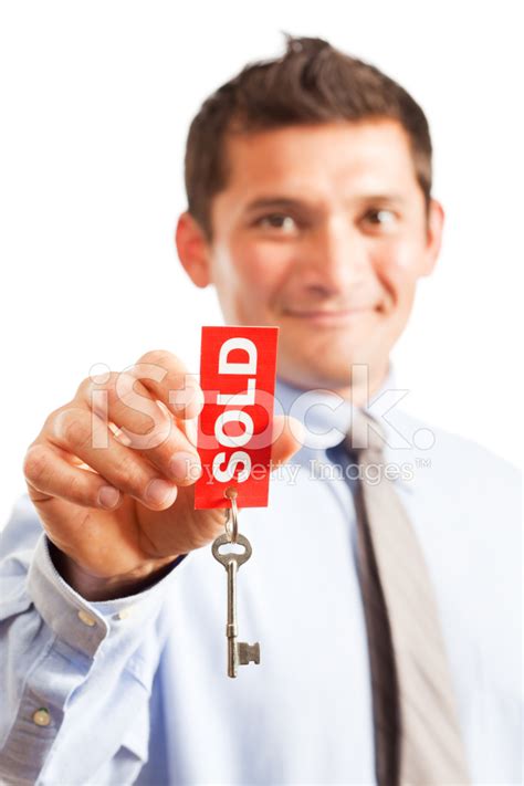 Real Estate Agent Holding Up House Key With Sold Sign Stock Photo