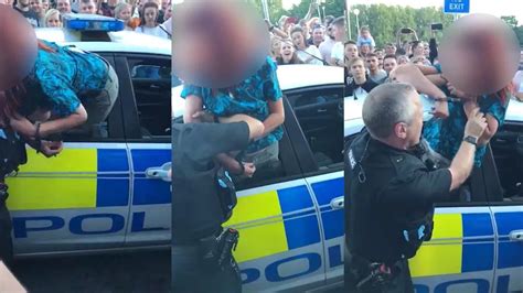 Handcuffed Woman Tries To Climb Out Of Police Car Window And Spits At Officers When They Try