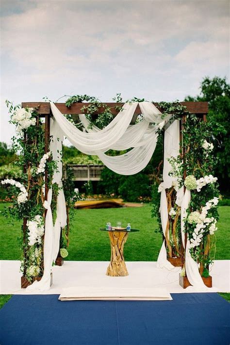 Arches can be made from quite a few materials, although more often than not they're made out of wood. Picture Of lush arch with white fabric and a lot of ...
