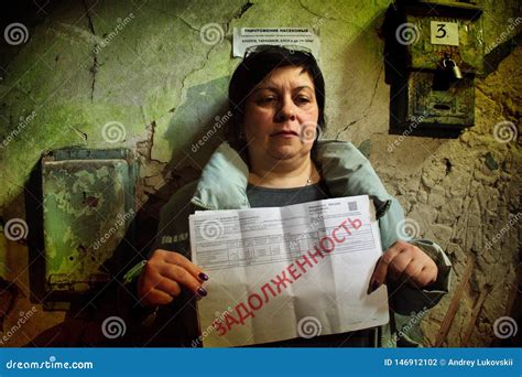 A Woman Holds A Bill For An Apartment With The Inscription In Russian