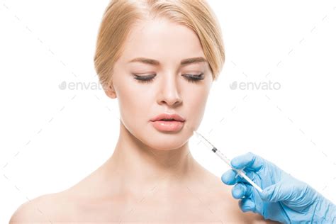 Beautiful Naked Woman Receiving Beauty Injection In Face And Looking Down Isolated On White