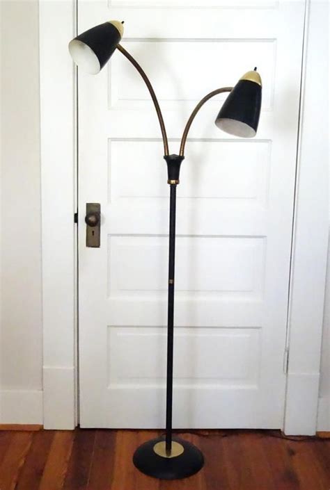 A Mid Century Modern Gooseneck Floor Lamp With Two Cone Shaped Lights