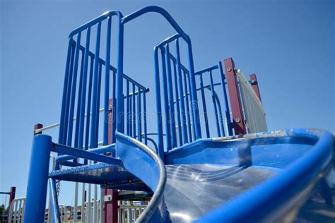 Colourful Playground Slide In School Yard With School In Background