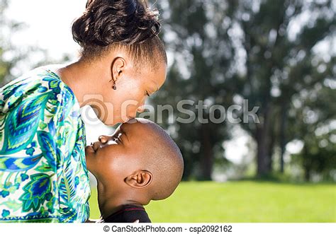 Cuidar A La Familia Una Madre Africana Que Besa La Cabeza De Sus Hijos