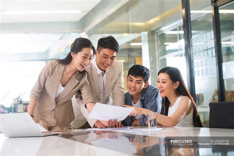 Young Professional Asian Business People Working With Papers In Office