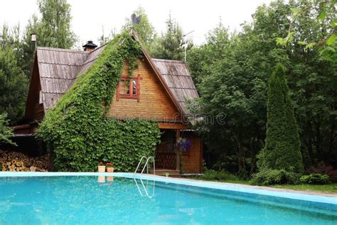 Country Cottage House With Ivy Facade And Open Air Swimming Pool Stock
