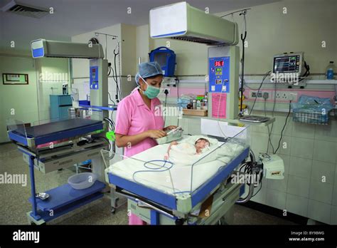 Nurse Tending To Newborn Baby In Hospital Nursery Stock Photo Alamy