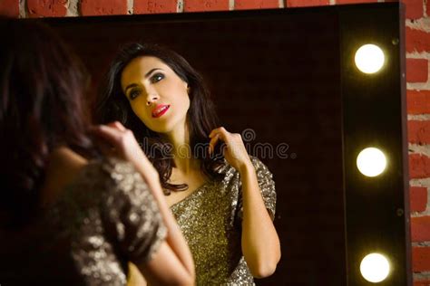 Portrait Of Young Beautiful Woman Standing Near Mirror With Stock Photo