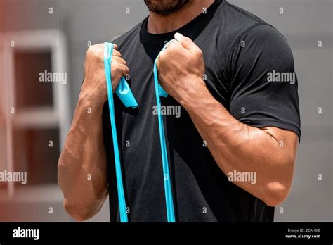 Fit Muscular Sports Man Doing Bicep Curl Exercise With Resistance Band