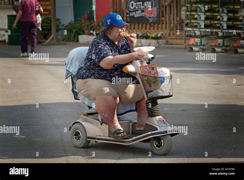 Overweight Male On Motorized Wheel Chair Eats Food Stock Photo Alamy