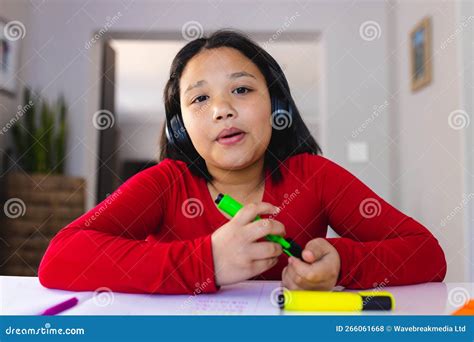 Happy Asian Girl Sitting At Table Using Laptop For Online Lesson Stock