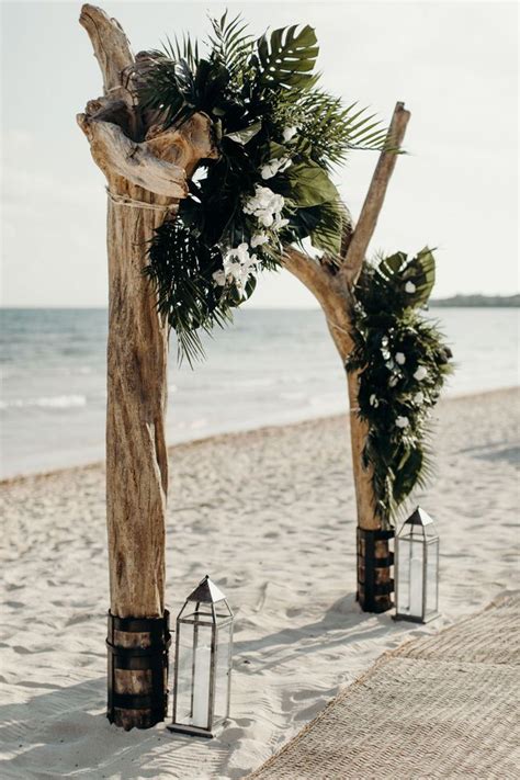 A Dramatic Driftwood Beach Wedding Arch With Palm Fronds To Die For