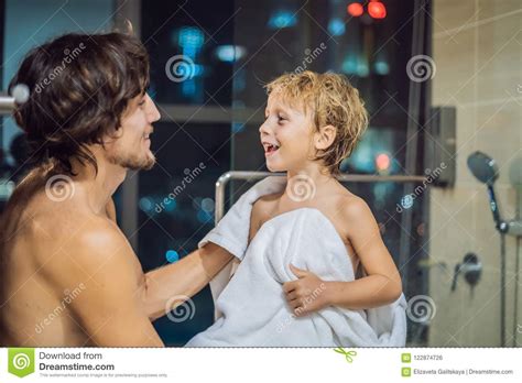 Dad Wipes His Son With A Towel After A Shower In The Evening Before