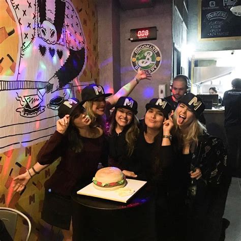 A Group Of Women Standing Next To Each Other In Front Of A Cake