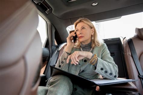 Businesswoman Sitting By Open Window In Car And Driving To Office For