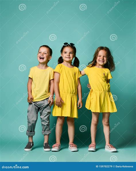 Full Body Shot Of Three Children In Bright Clothes Two Girls And One