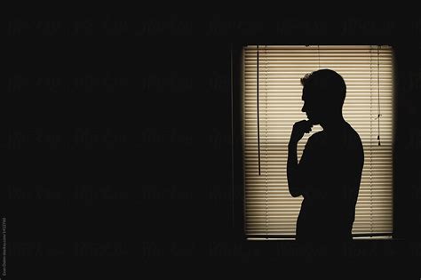 Silhouette Of Man In Window Del Colaborador De Stocksy Evan Dalen