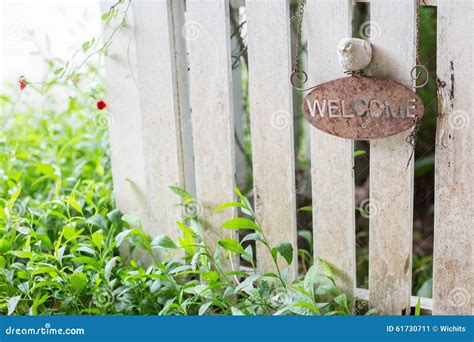 Rustic Welcome Sign With Red Flower Hanging On Distressed Antique Green