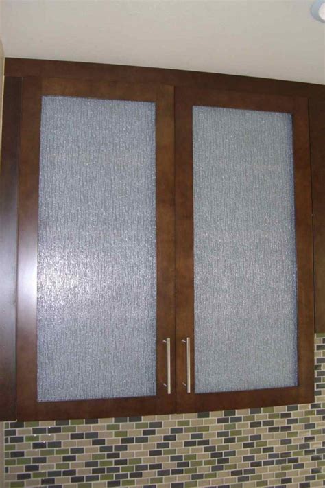 A glass tile backsplash and glass cabinet doors reflect the light. Frosted Rain Glass - Sans Soucie Art Glass