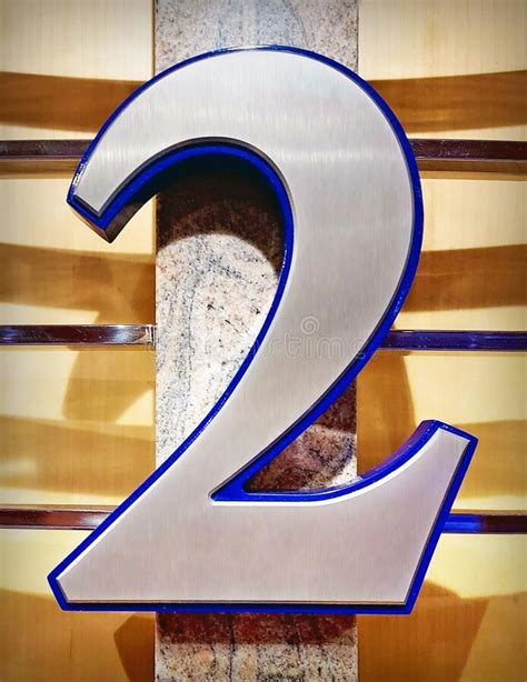Number Two Signage In Scratched Metal Mounted On A Wooden Wall Stock