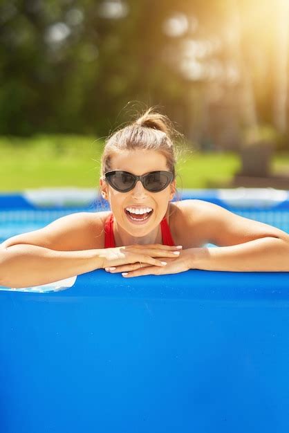 Premium Photo An Attractive Young Woman Relaxing On Swimming Pool In The Backyard