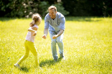 Premium Photo Father Chasing His Cute Little Daughter While Playing