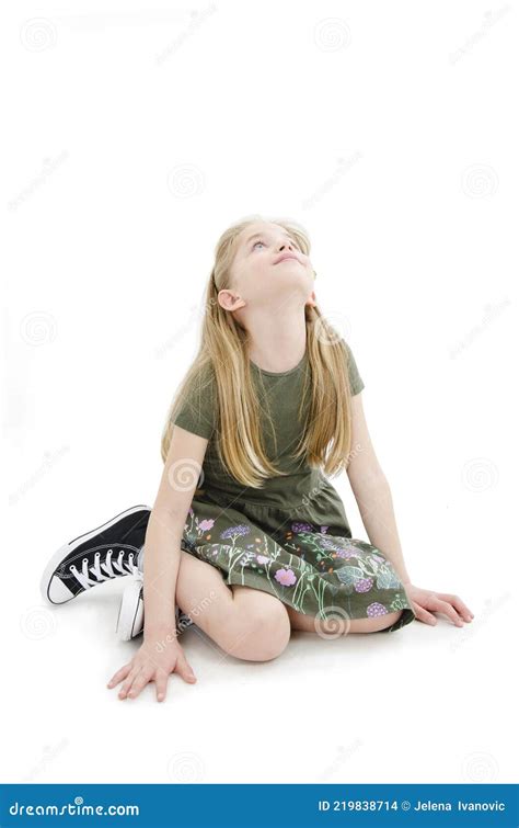 Portrait Of A Cute Girl Sitting On The Knees Looking Up On Copy Space Stock Photo Image Of