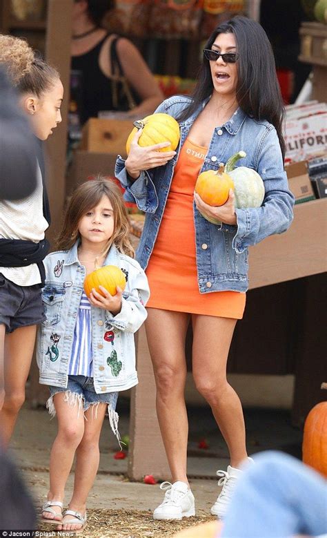 the mother and daughter are holding pumpkins