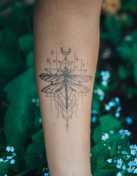 A Womans Leg With A Dragonfly Tattoo On It And Flowers In The Background