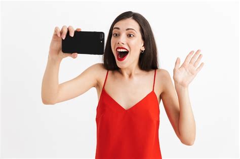Retrato De Una Mujer Joven Emocionada En Vestido Aislado Teniendo Selfie Con Teléfono Móvil