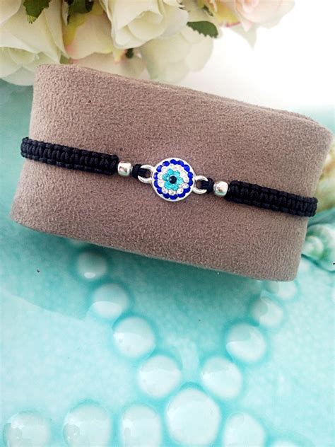 A Bracelet With An Evil Eye Beaded On It Sitting Next To A Bouquet Of