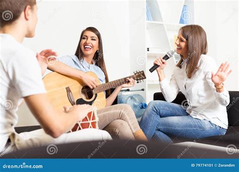Friends Enjoying Playing Guitar And Singing Together Stock Image
