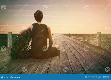 Man Sitting On A Jetty Stock Photo Image Of Distant 49984326