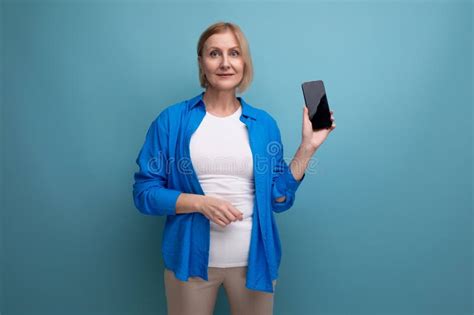 A Woman Of Mature Years Uses A Payment System Remotely Using A Credit Card And A Smartphone On A