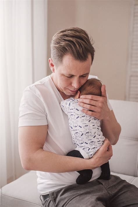 Father Gently Hugging And Soothing His Newborn Baby Del Colaborador De Stocksy Lea Csontos