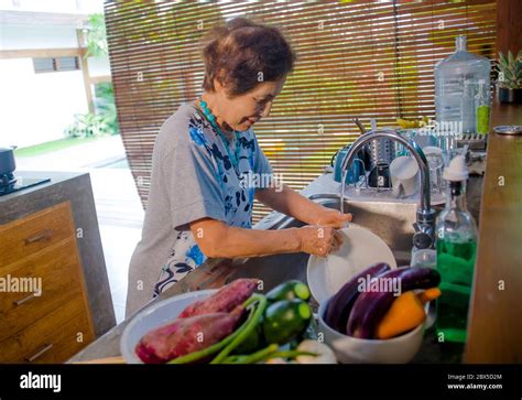 Lifestyle Portrait Of Senior Happy And Sweet Asian Japanese Retired Woman Cooking At Home