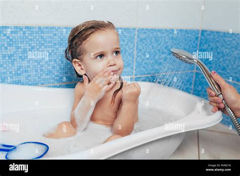 Beautiful Little Girl Taking A Bath At Home A Cute Baby Is Sitting In