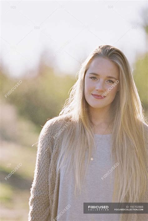 Portrait Of Young Adult Woman With Long Blonde Hair In Garden