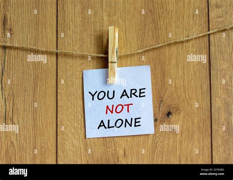 Wooden Clothespin With White Sheet Of Paper Text You Are Not Alone