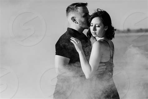 Guy And A Girl In Black Clothes Hug Inside A White Smoke By Andrii Omelnytskyi Photo Stock