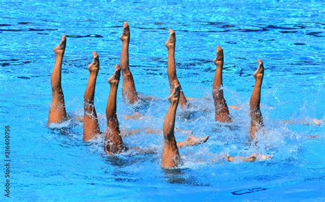 Foto Stock Synchronized Swimmers Point Up Out Of The Water In Action