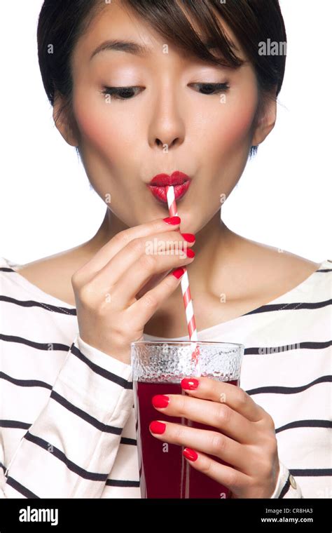 Young Woman Drinking From Straw Against White Background Stock Photo