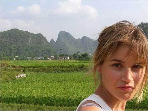 A Woman Is Standing In Front Of Mountains And Green Grass With Her Eyes