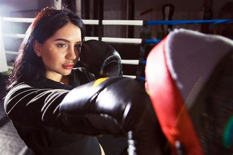 Premium Photo A Beautiful Girl In Boxing Gloves Hits Her Paws In The Ring