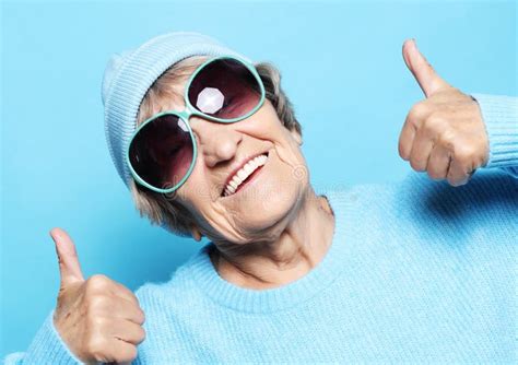 Lifestyle Emotion And People Concept Funny Old Lady Wearing Blue Sweater Hat And Sunglasses