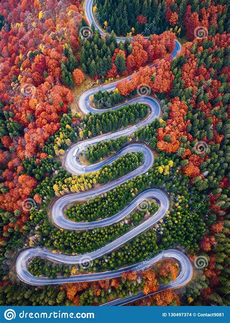 Winding Road From High Mountain Pass In Autumn Season With Orange