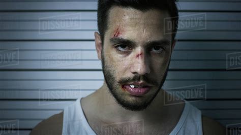 Close Up Portrait Shot Of An Arrested Beaten Man In A Police Station