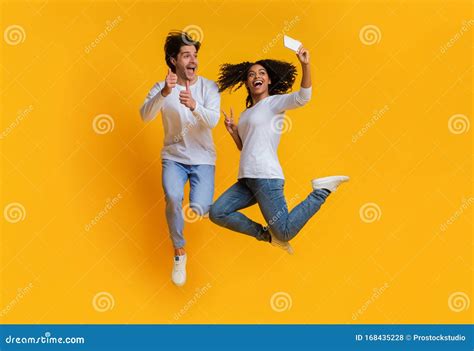 Couples Interraciaux Joyeux Prenant Le Selfie Sauter Tout En Samusant Ensemble Photo Stock