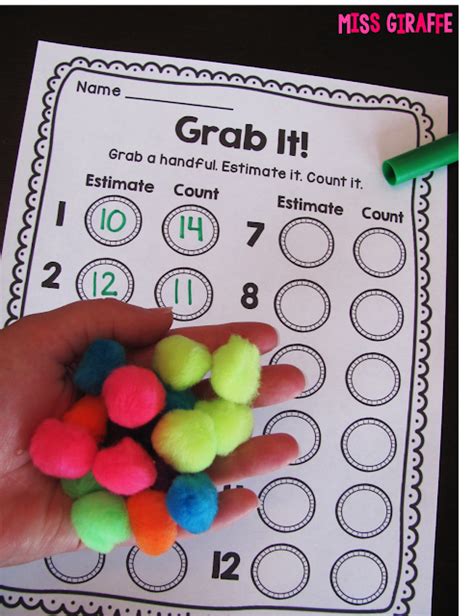A Hand Holding Some Colored Pom Poms In Front Of A Printable Game