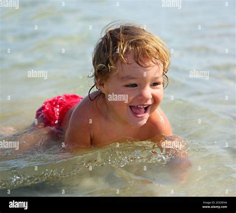 Child Bathing In Sea On Beach Stock Photo Alamy